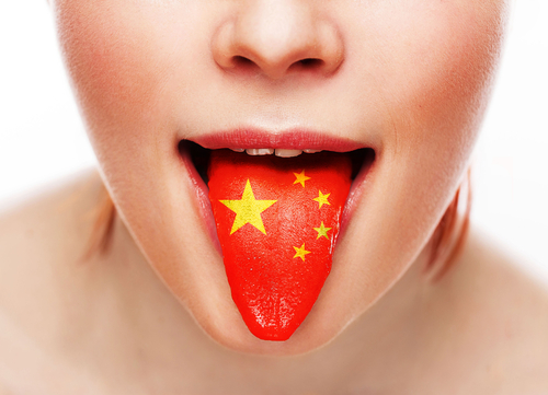 中国国旗を誇らしげに舌に掲げる女性。