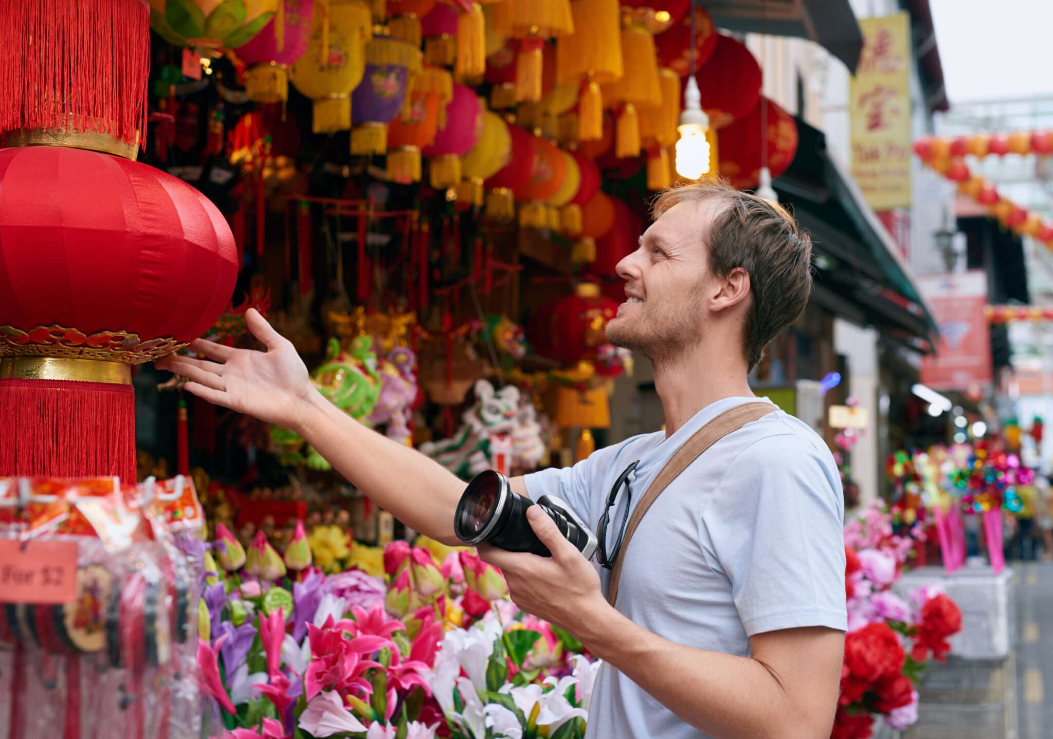 にぎやかな市場で活気に満ちた中国の提灯を撮影している男性。