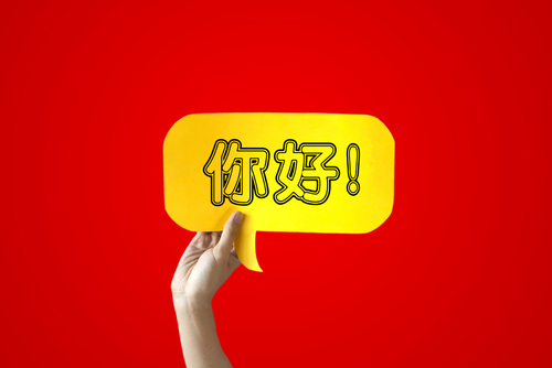 「中国」と書かれた黄色の吹き出しを持つ手。