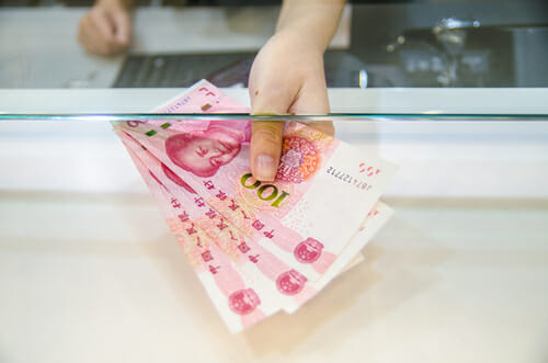 カウンターの前で手には中国の通貨の束が握られています。
