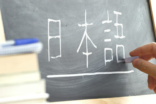 黒板に中国の文字を書く人。