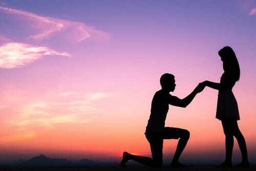 中国の夕暮れ時に女性にプロポーズする男性のシルエット。