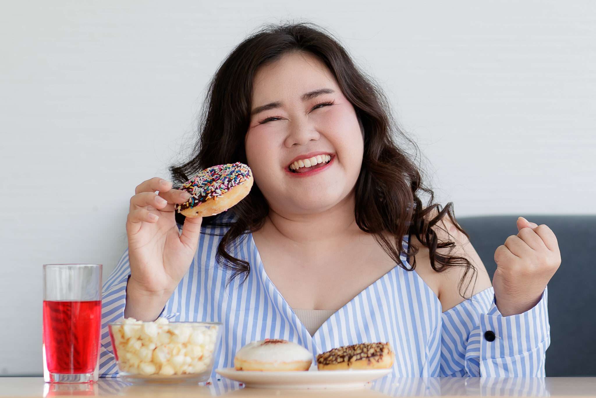 中国で女性がドーナツとポップコーンを食べている。