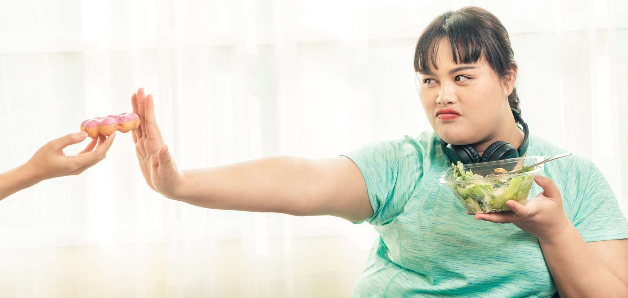女性にサラダを盛り付ける中国人女性。