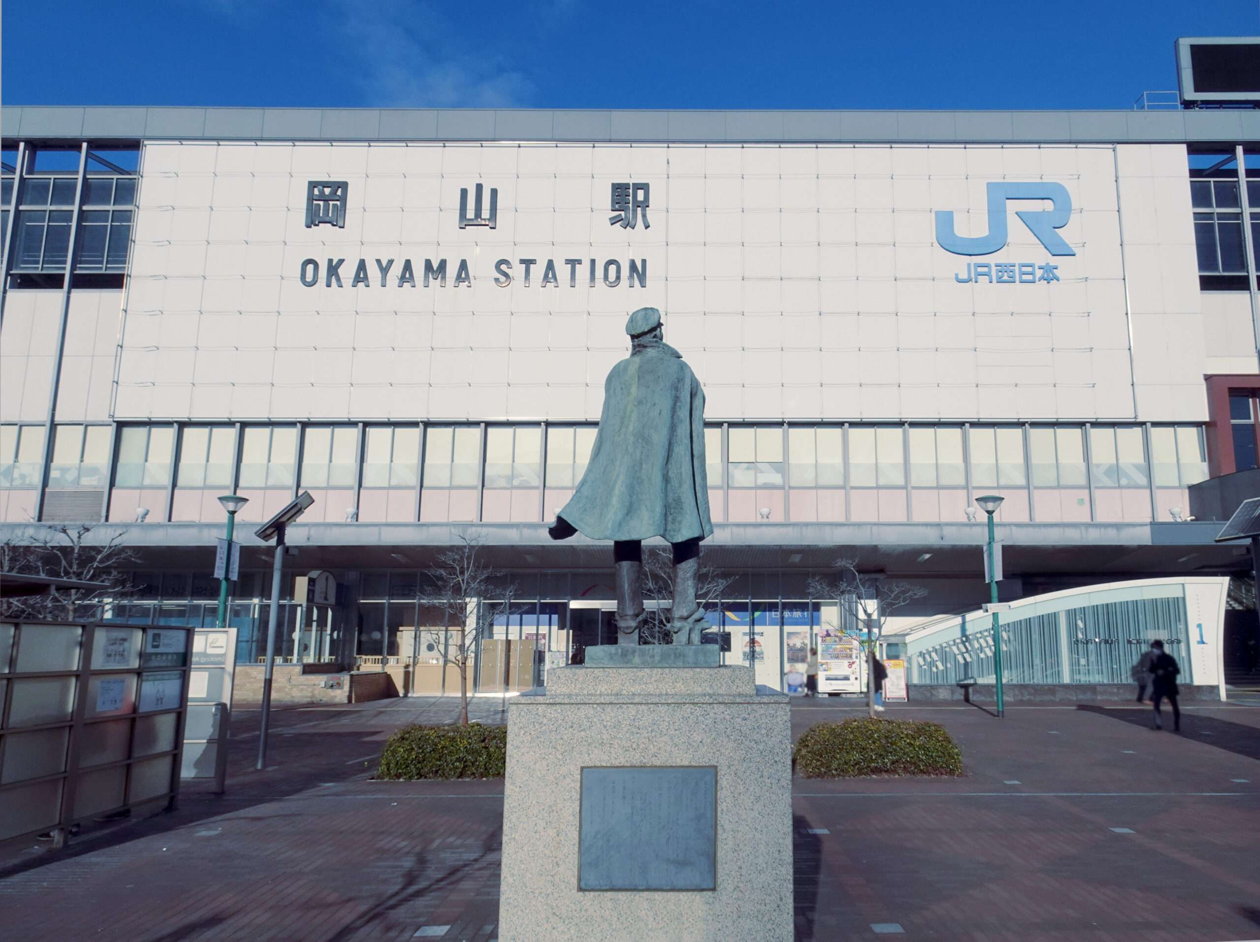 岡山駅前には青空をバックに堂々と立つブロンズ像が立ち、岡山・倉敷の風情を象徴する光景が広がっています。