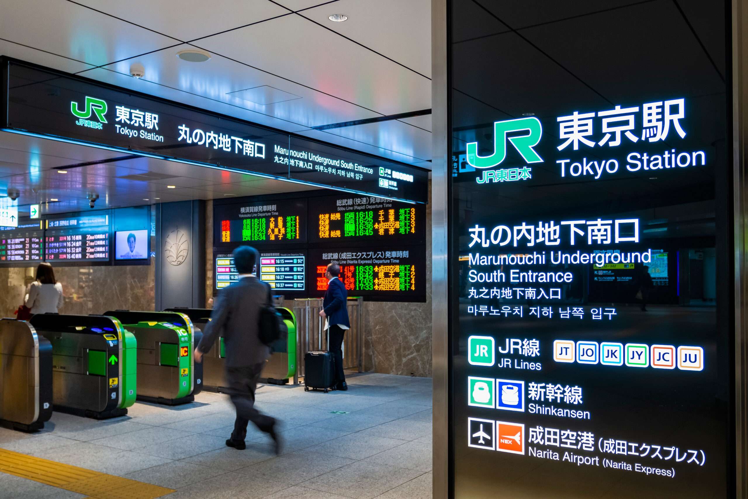 東京駅の入り口は、改札口や多言語で列車の時刻表を表示するデジタル看板を通る旅行者で賑わっており、東京の中国語教室で見られる多言語環境を彷彿とさせます。
