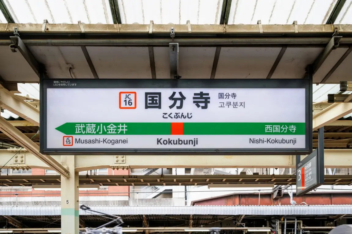 武蔵小金井方面、西国分寺方面を表示する国分寺の駅名標。日本語、英語、ハングルで書かれている。.