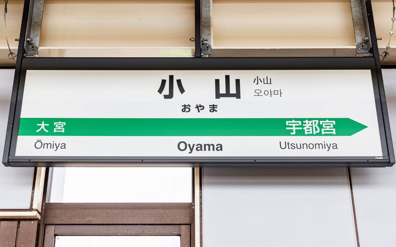 大宮方面、宇都宮方面を示す小山駅の案内標識。日本語、英語、韓国語の文字がある。.
