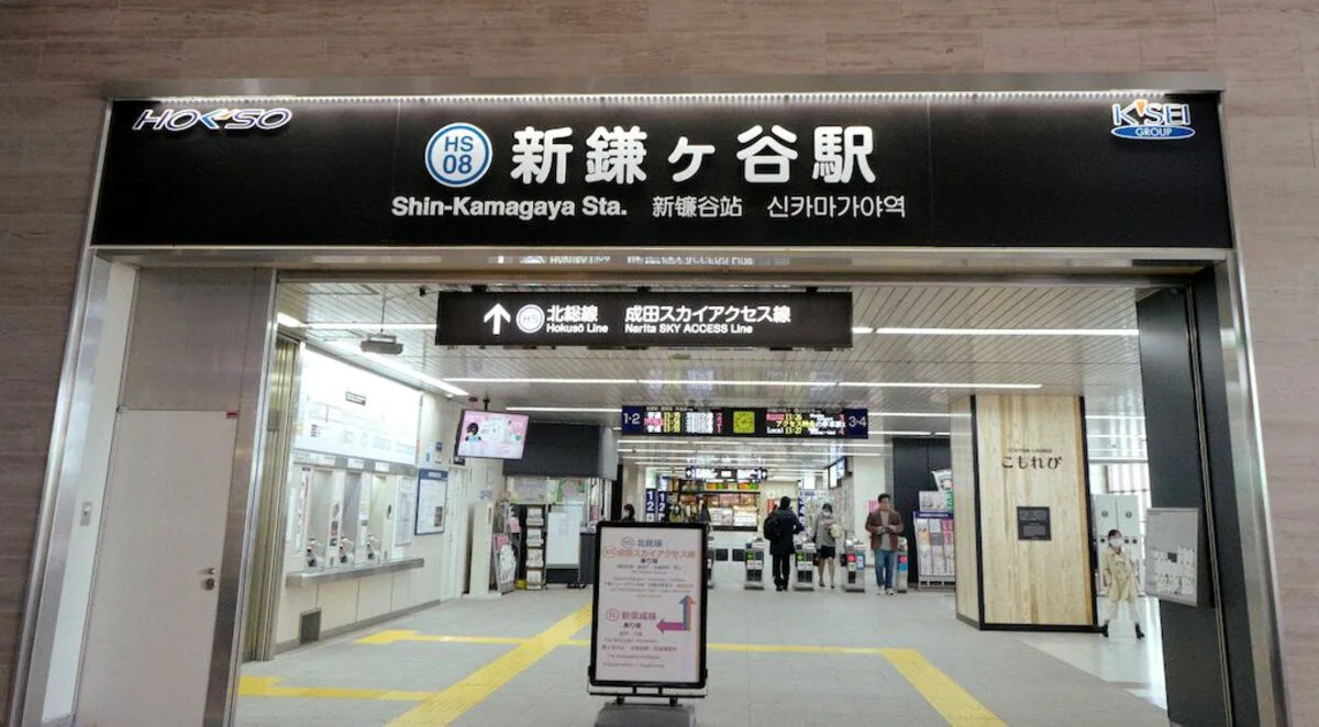 自動券売機、日本語、英語、韓国語の表示、改札口上部のデジタル表示。.
