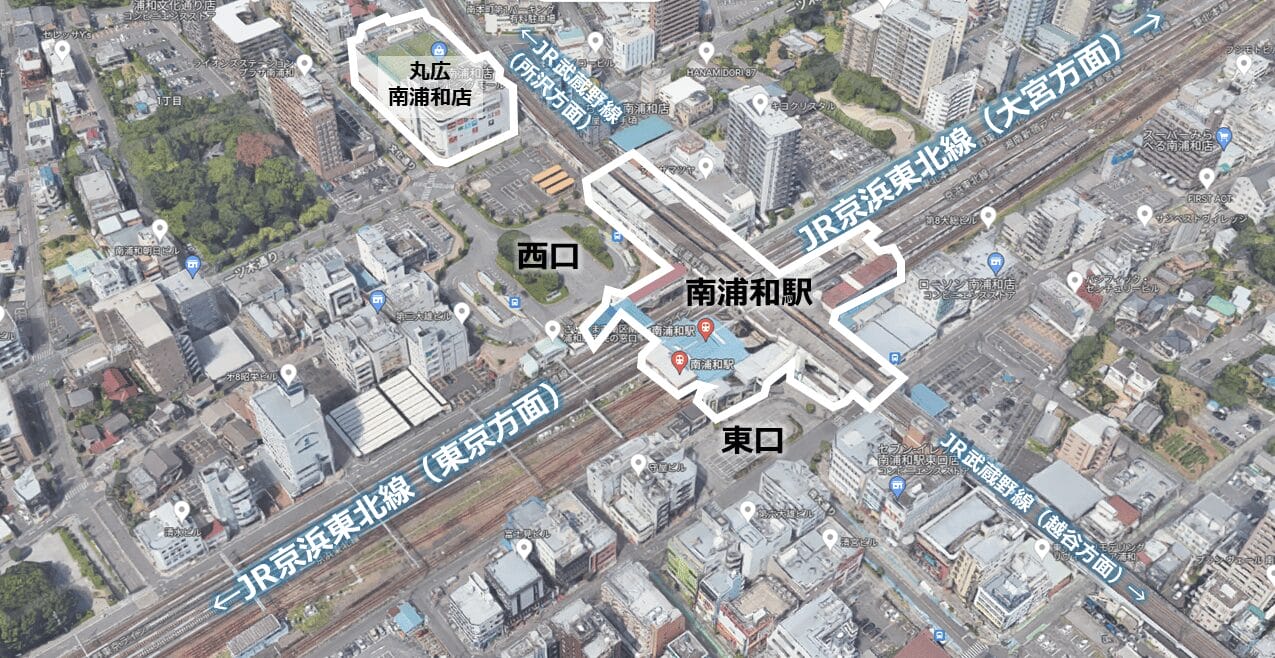日本の南浦和駅の航空写真。表示された出入り口、線路、周辺の建物、主要道路を示す。.